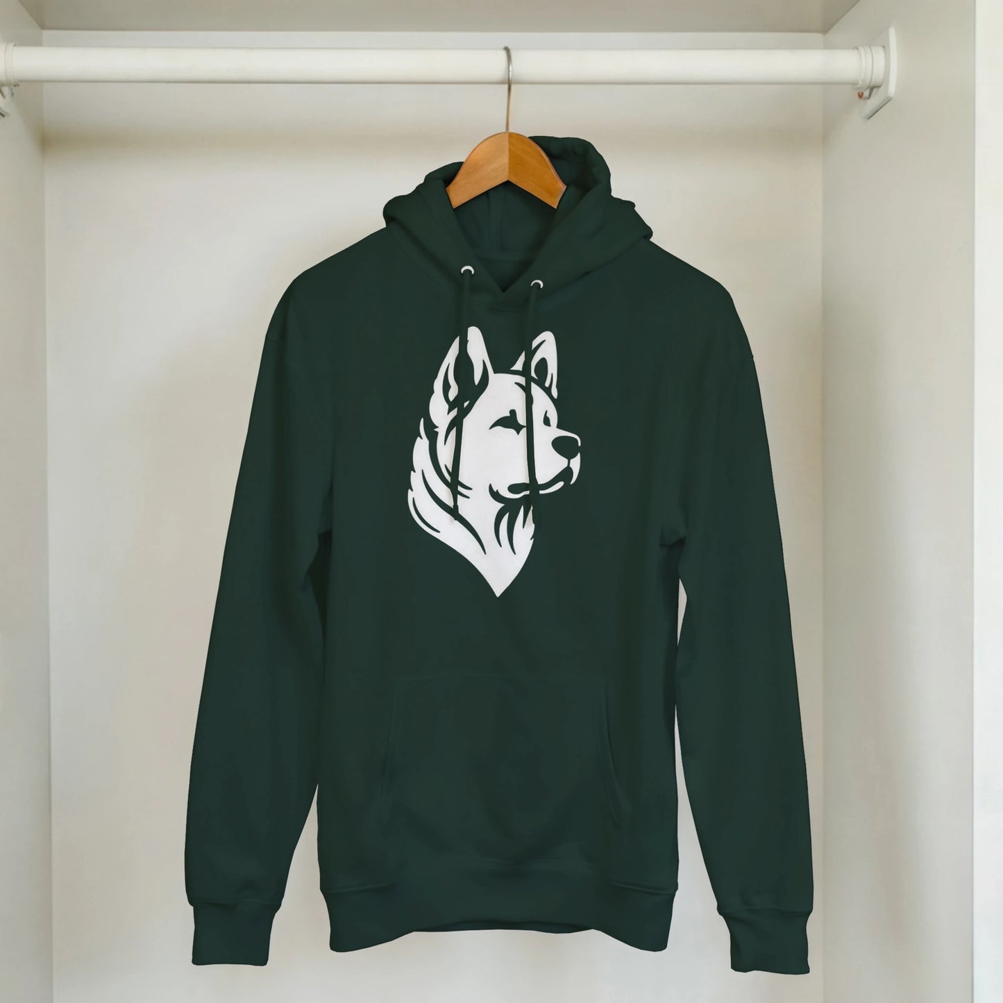 Green hoodie with a white dog graphic on a hanger against a white wall.