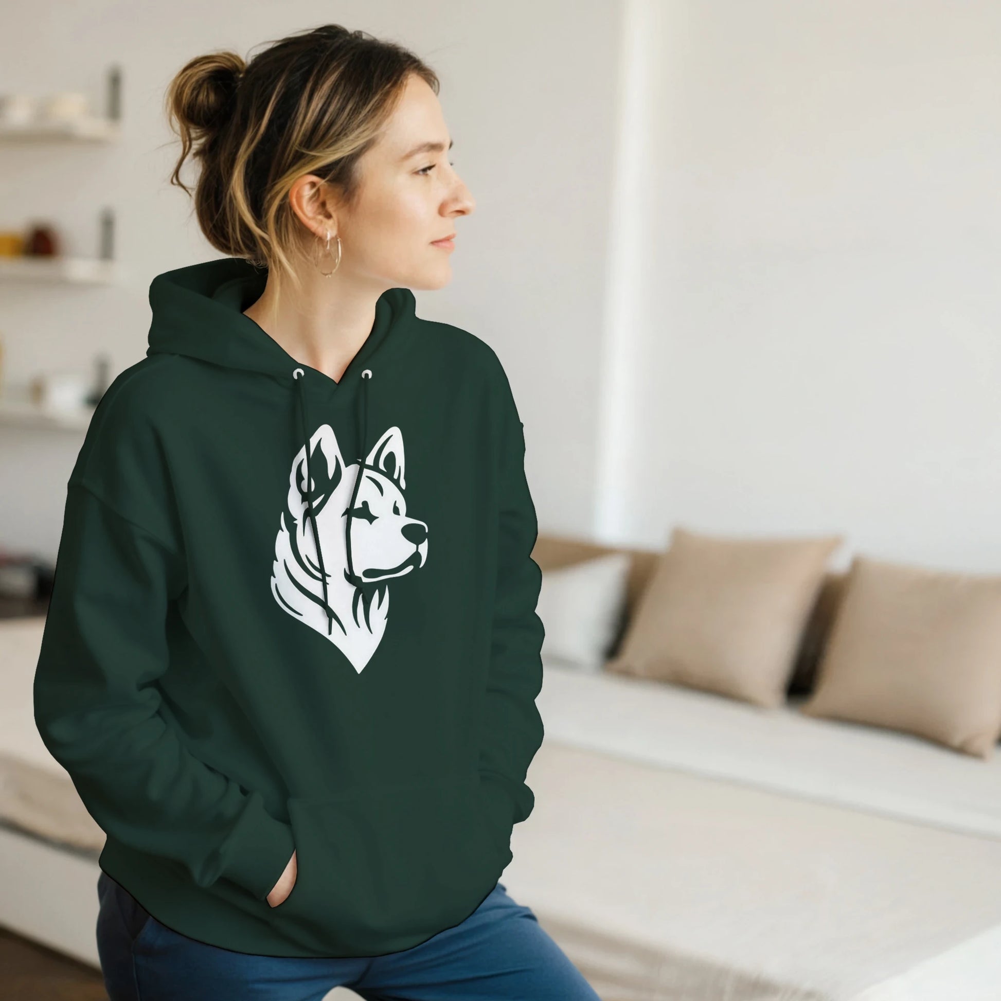Person wearing a green hoodie with a dog graphic in a living room.