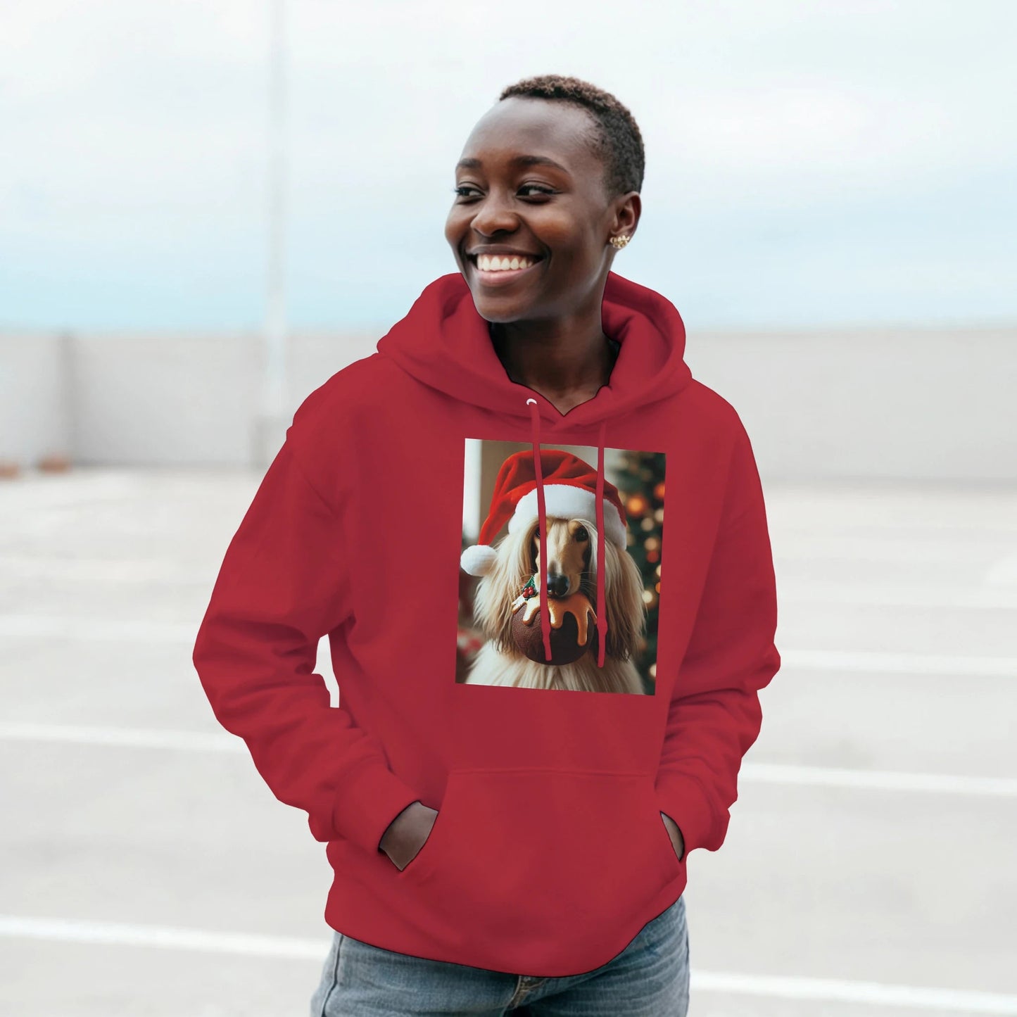 Person wearing a red hoodie with a dog wearing a Santa hat design on a light background