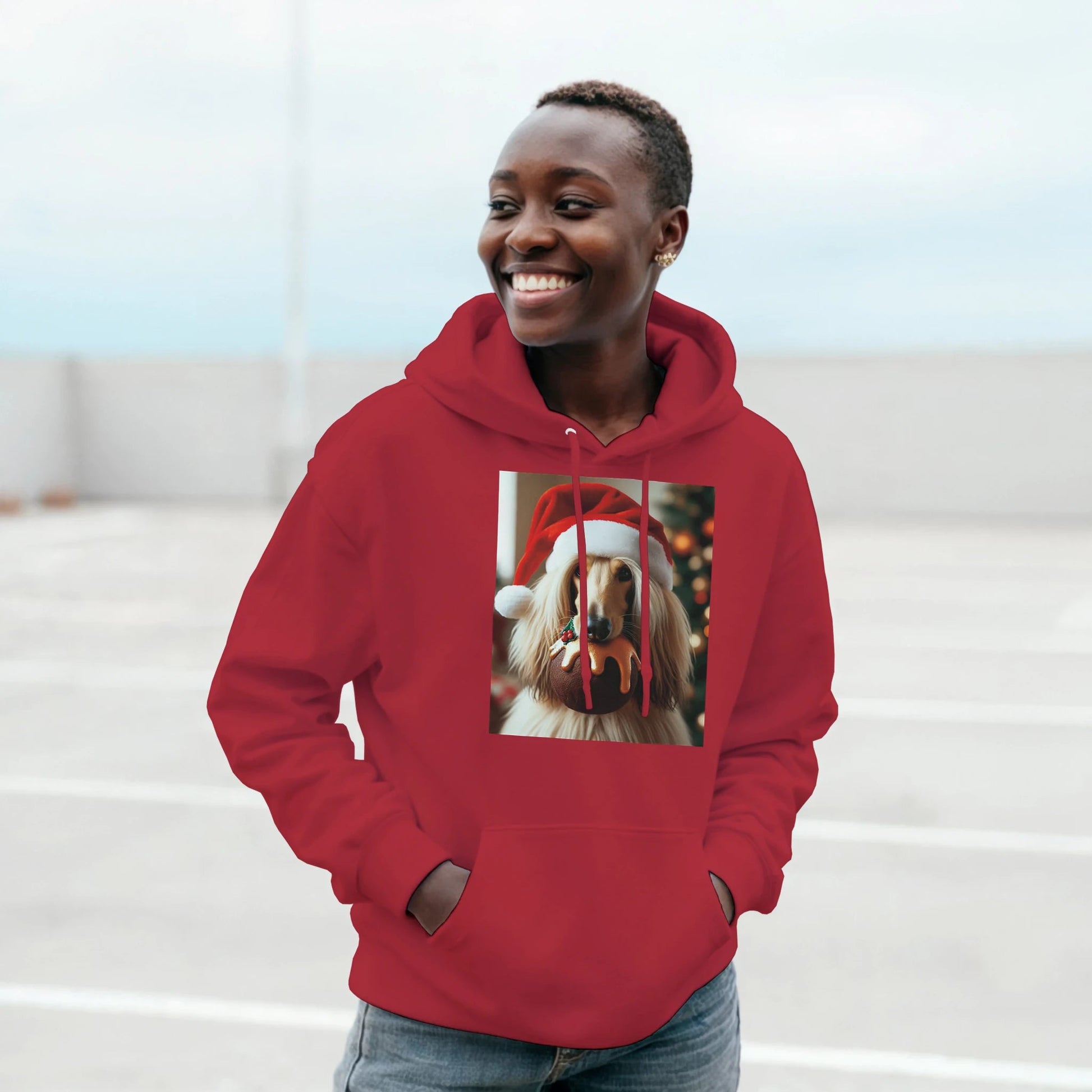 Person wearing a red hoodie with a dog wearing a Santa hat design on a light background